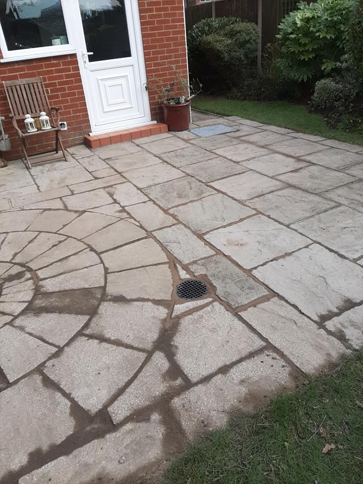 Laying a drain under a new patio due to flooding .